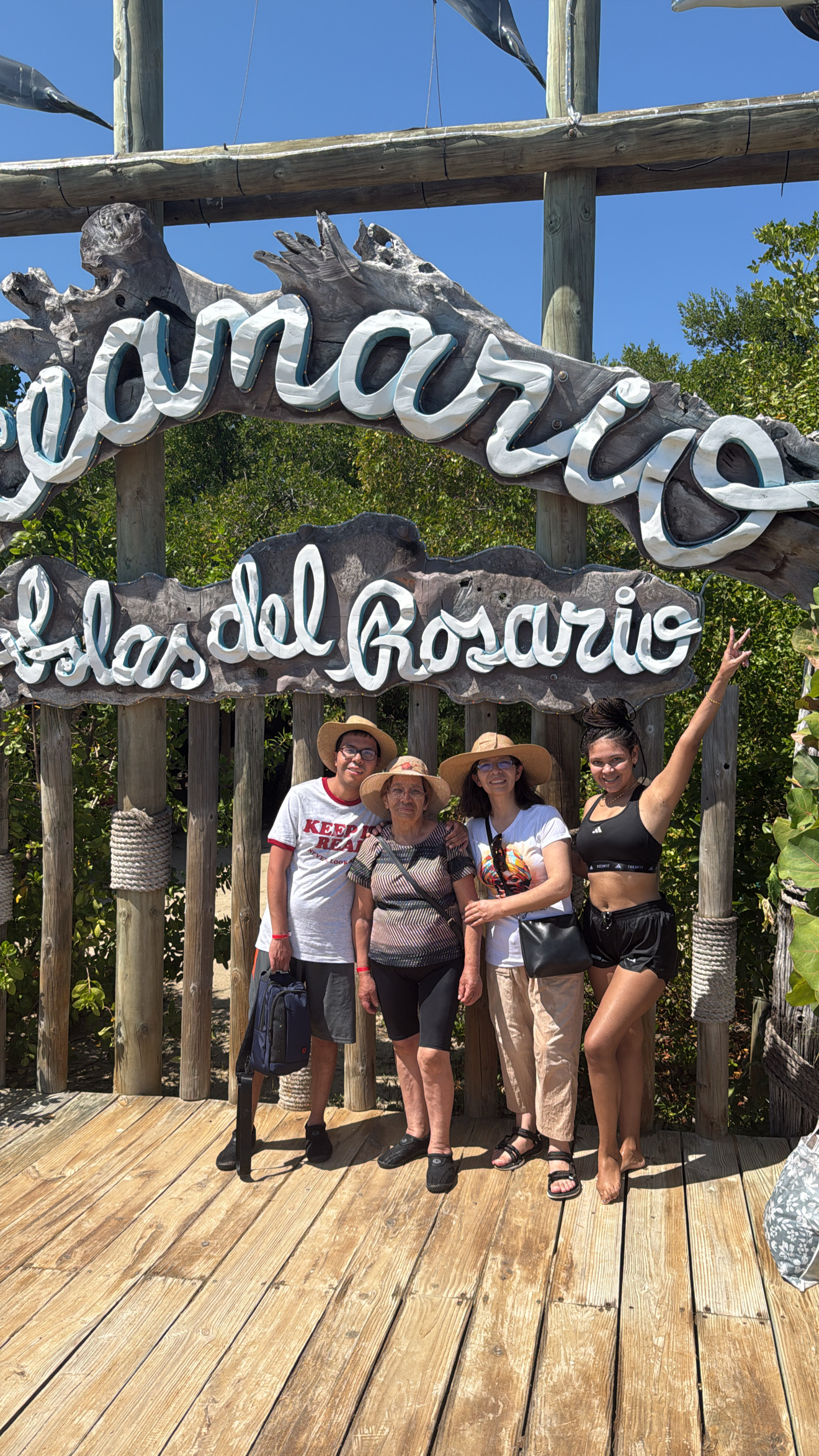 Familia posando en el letrero del Oceanario Islas del Rosario durante su experiencia en Cartagena